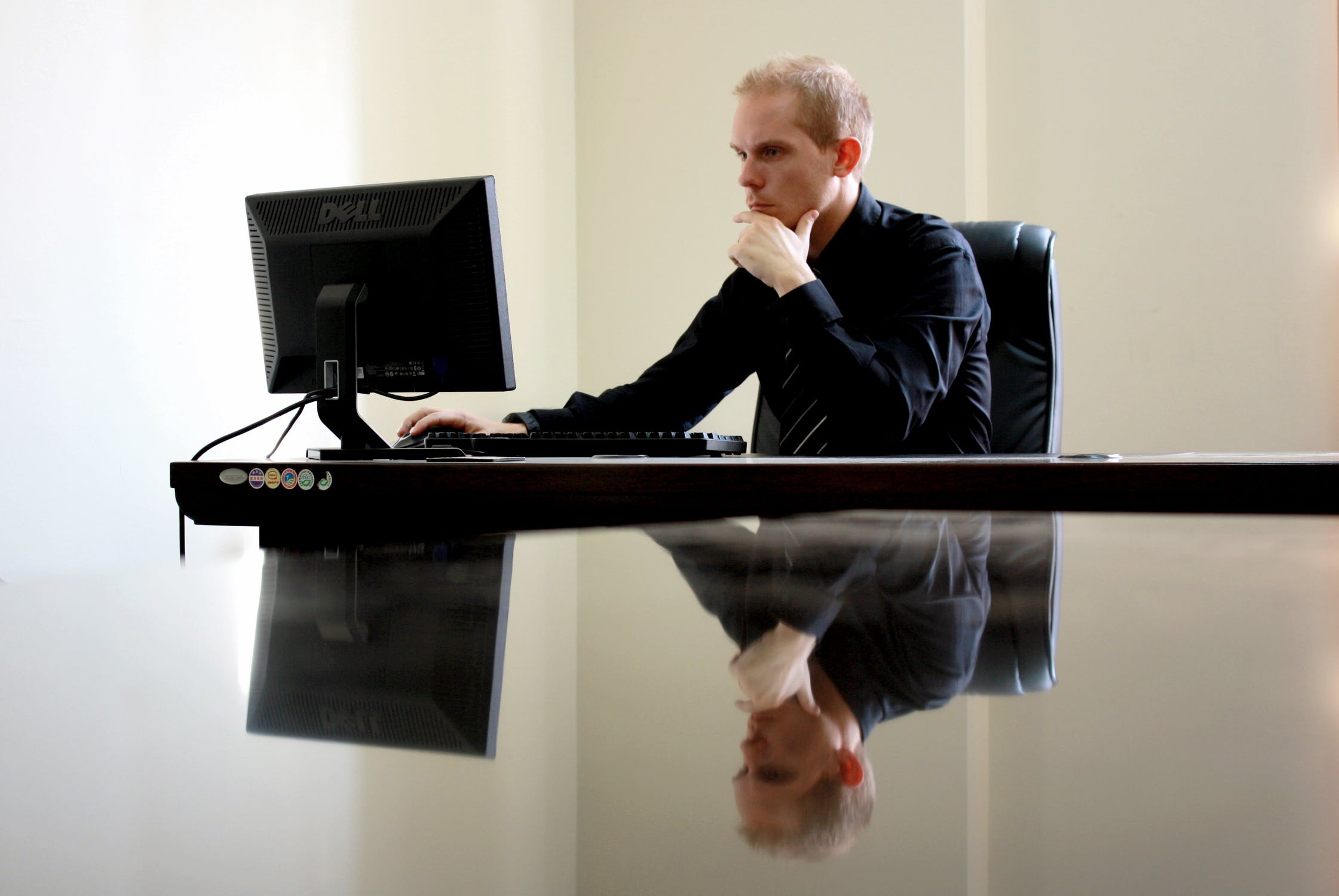 Homem no computador vendo qual é a importância do capital social.